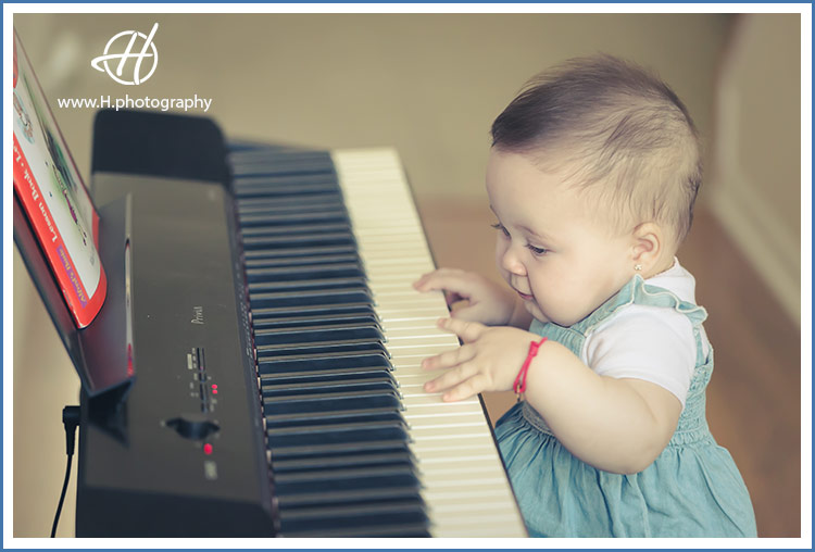 baby posed by piano