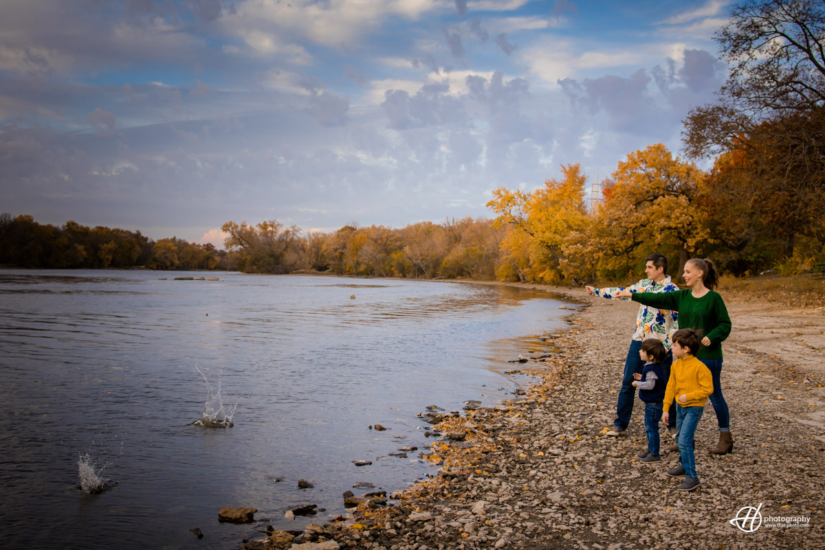 The Woodcox family playing together by Fox River at Fabyan Forest preserve. 