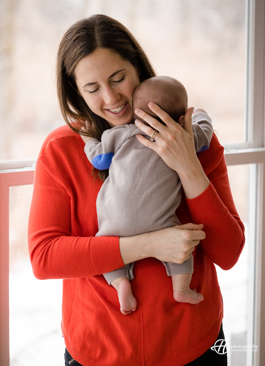 moment of connection between a mother and her baby. Alison is seen holding her baby, with her eyes closed, in a pose that conveys a sense of deep affection and love. The image captures the intimacy and tenderness of the mother-child relationship.