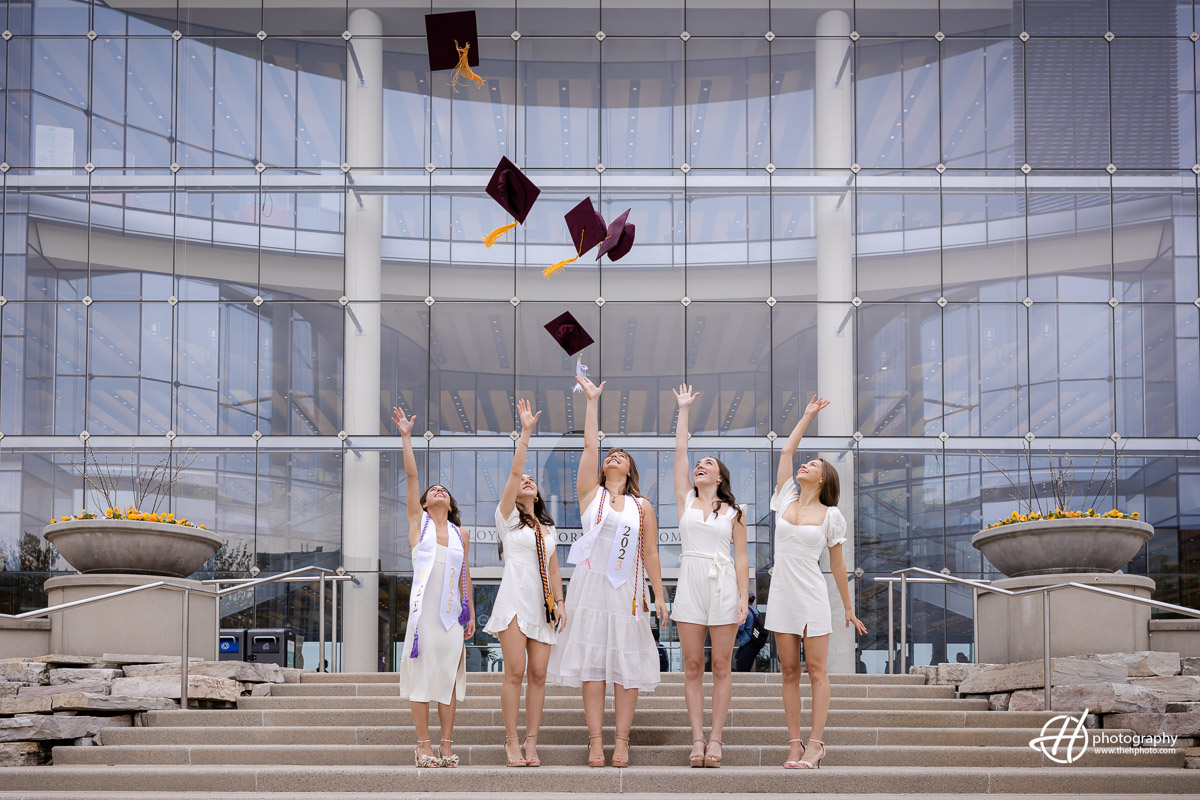 Celebrating triumphs and new beginnings: A group of jubilant Loyola University Chicago seniors toss their caps high into the air, symbolizing their graduation and embracing the exciting adventures that lie ahead