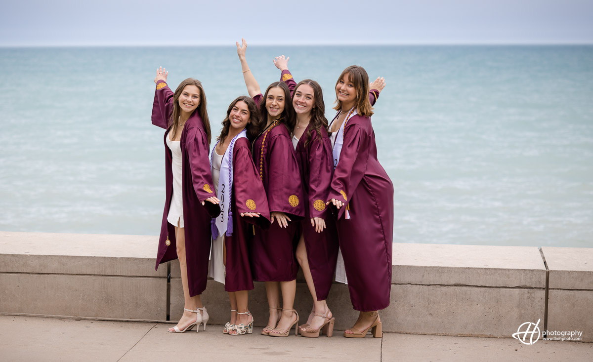 Group of Loyola Students posing in front of Lake Michigan in Chicago by their campus. 