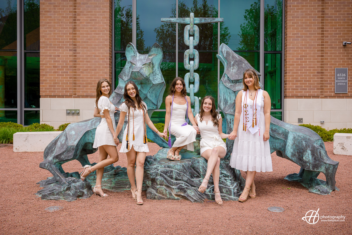 A sisterhood of strength and resilience: Loyola University Chicago senior girls stand proudly in front of the iconic statue featuring wolves, symbolizing their unity, determination, and unwavering spirit as they conquer challenges together