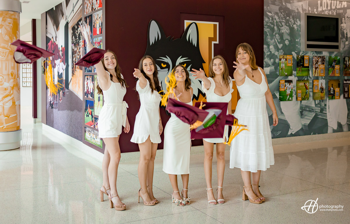 A thrilling moment of triumph: Loyola University Chicago seniors jubilantly toss their caps high inside the athletic building, capturing the exhilarating joy and sense of accomplishment as they bid farewell to their college years and embrace new adventures.