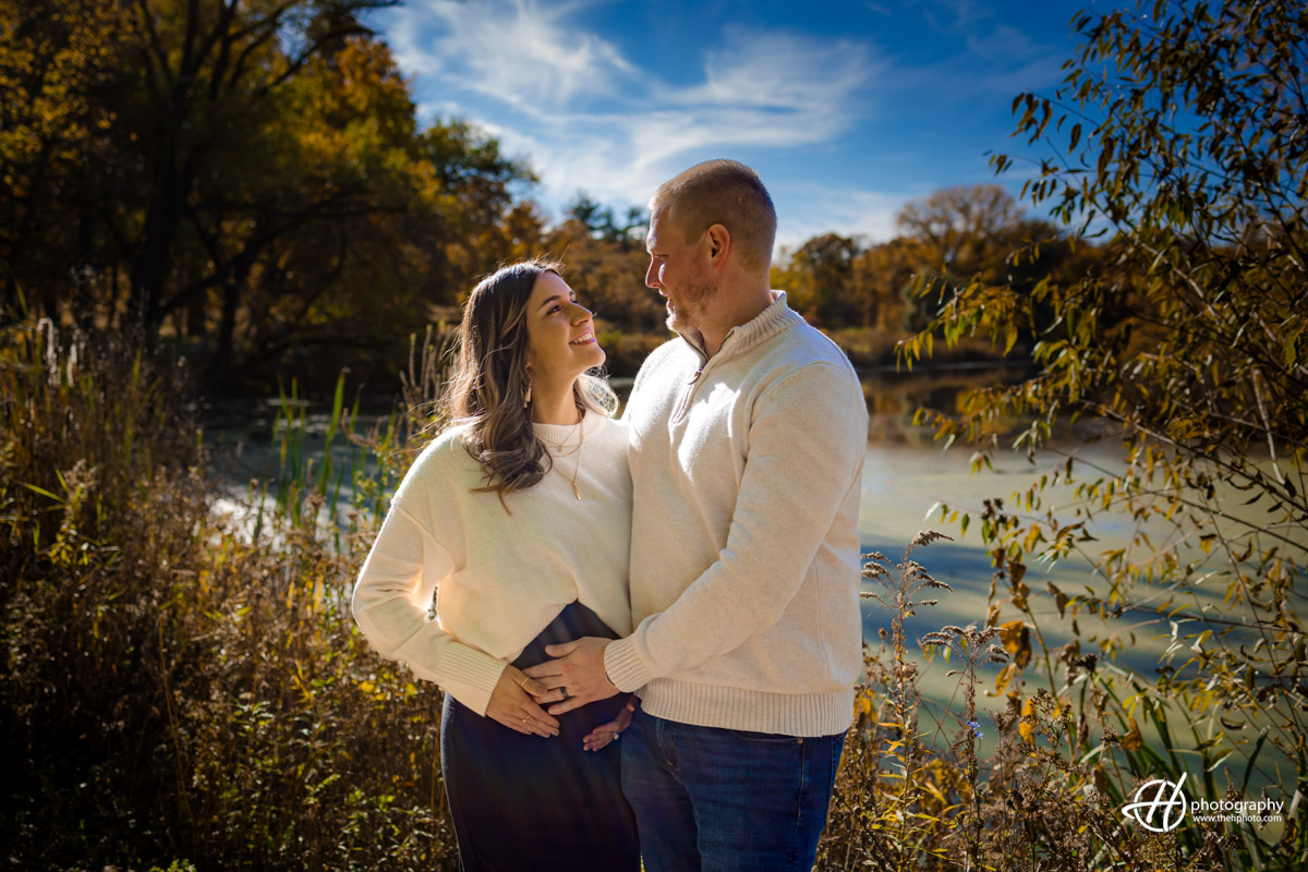 In a serene Barrington setting, Susana and Dan strike graceful maternity poses, showcasing the beauty of anticipation and love. The couple, bathed in soft natural light, radiates joy and connection as they embrace the excitement of expanding their family. The fall atmosphere adds a touch of warmth to this tender moment, preserving the essence of a magical maternity session in each frame.