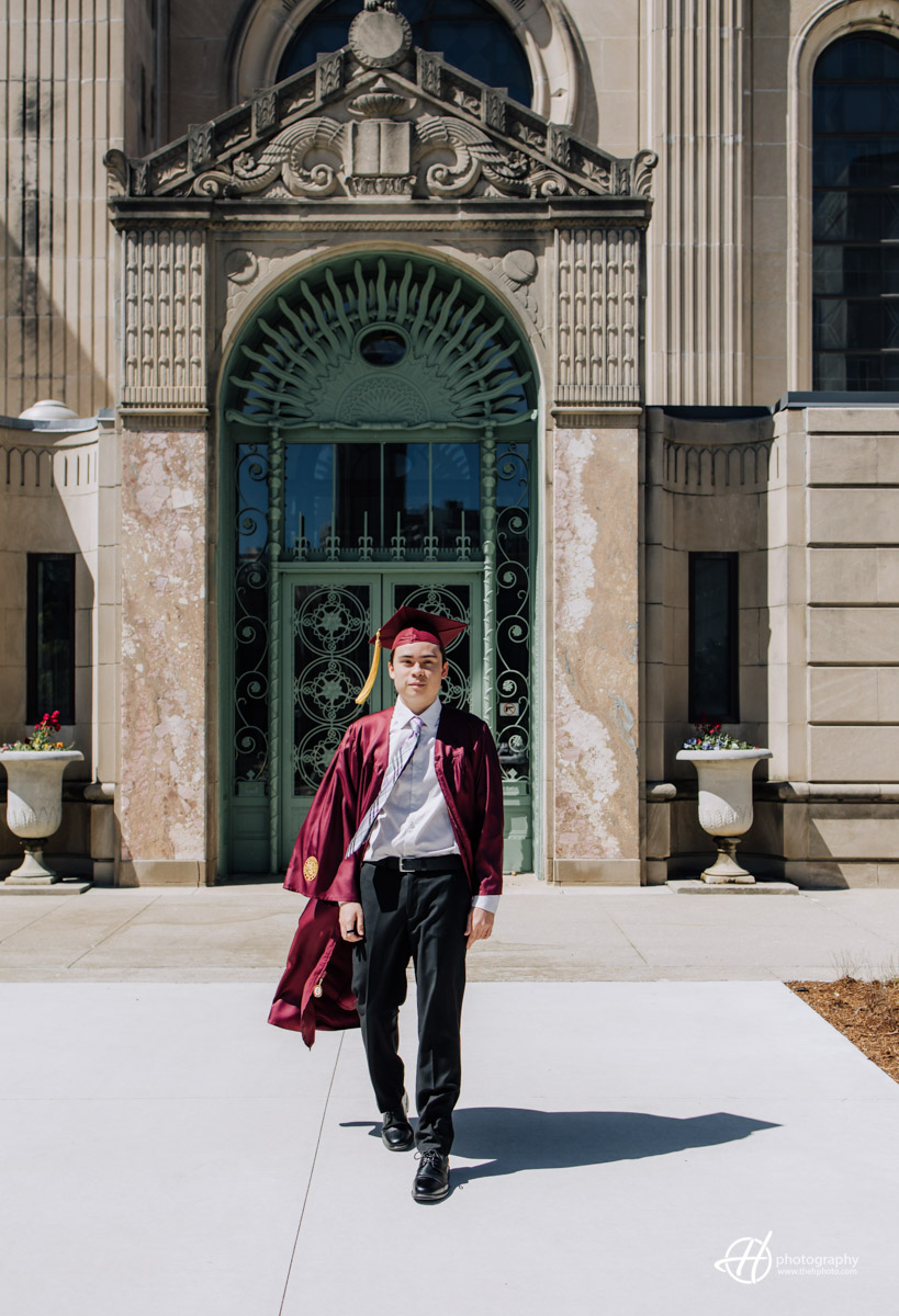 candid shot of Loyola Graduate by the green door at the library. 