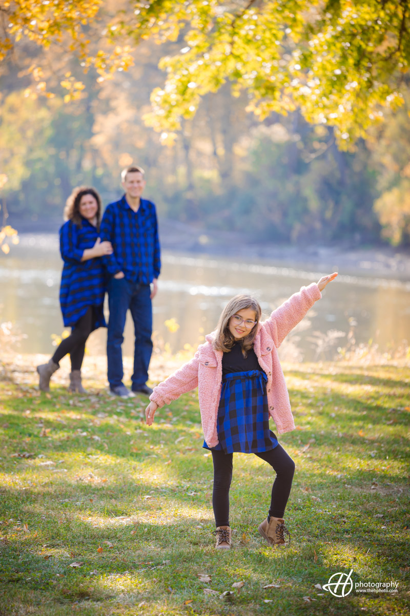 Gabriela posing while parents watch from background 