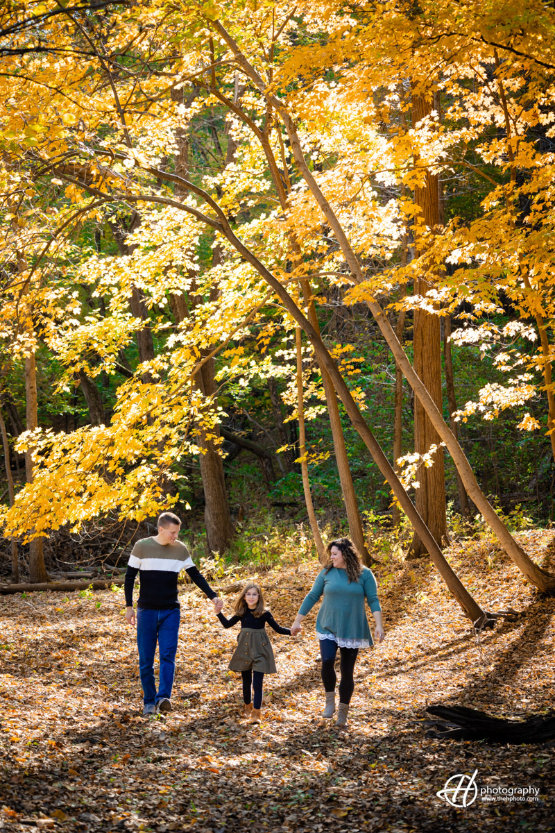 family walking through the forest in fall morning