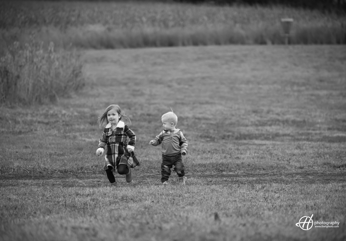 siblings  running through the fields in Carry IL 